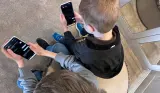 Two children using the Other Phone side by side at home, showing what the child-friendly smartphone looks like in real family use with SafetyMode parental controls