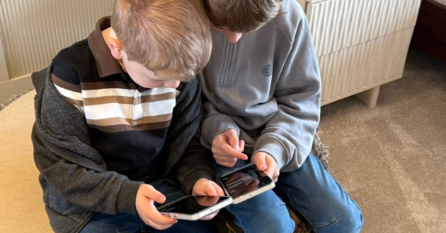 Two children using the Other Phone side by side at home, showing what the child-friendly smartphone looks like in real family use with SafetyMode parental controls