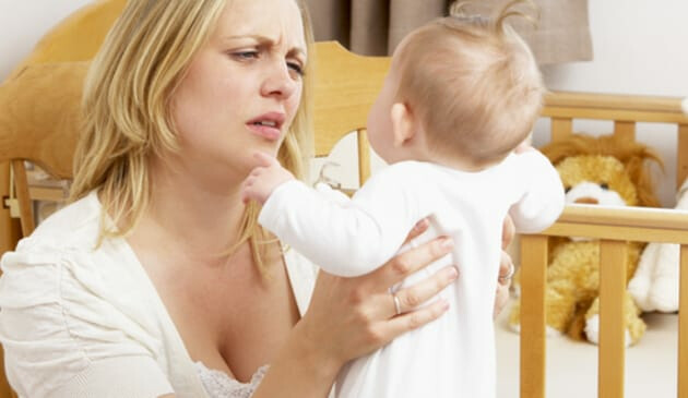 tired mum lifting baby