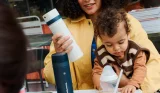 Mother with child on lap and Tommee Tippee PrepGo in hand