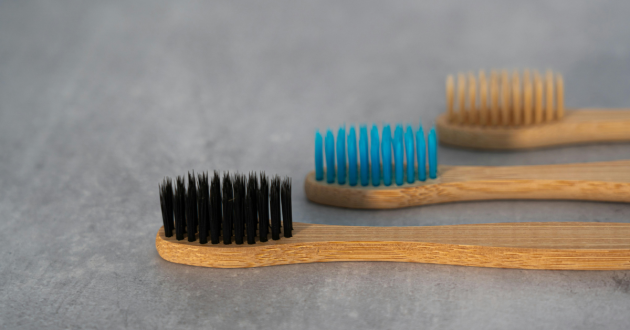 Three wooden toothbrushes lined up
