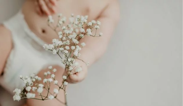 Baby holding flowers