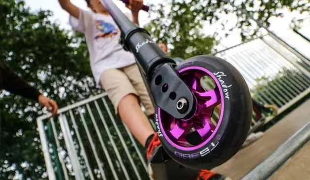 Close up shot of the shadow stunt scooter with a child riding on it