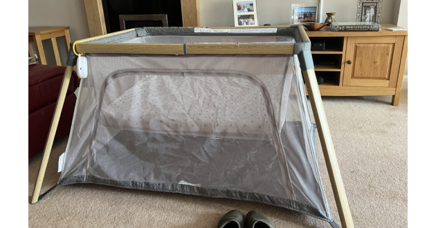 Tutti Bambini Cozee go travel cot review image of travel cot in a living room