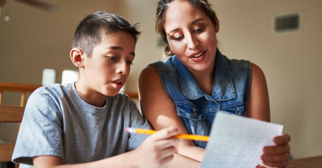 Mother and child doing homework together at home