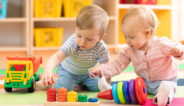 Two children playing with stacking rings at nursery
