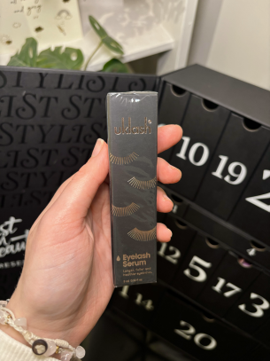 Georgia Mann's hand holding the uklash Eyelash Serum infront of the Stylist beauty advent calendar