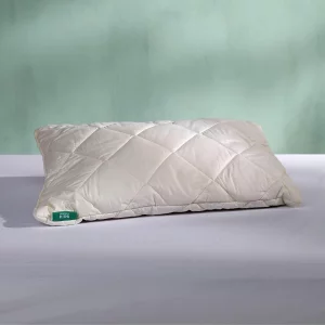 Woolroom Deluxe Washable Kids Cot Pillow pictured on a sheet