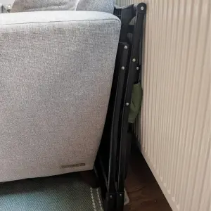 Ickle Bubba Flip Magic Fold Highchair review image showing chair folded behind sofa