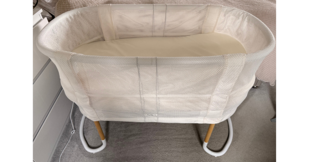 Babybjorn baby crib review image showing crib next to bed in testing