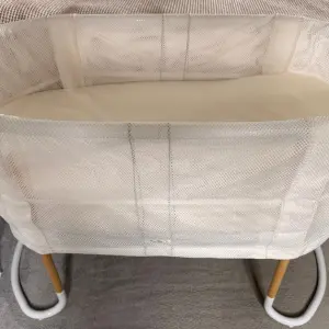 BabyBjörn Baby Crib review image of crib next to bed