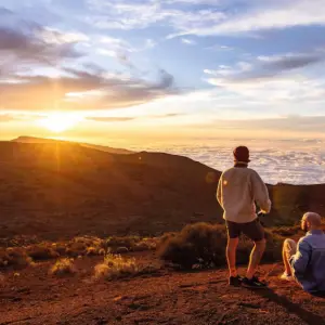 Couple hiking at sunset in Tenerife wearing winter gear