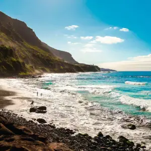 Landscape shot of a shoreline in Tenerife with crashing waves and turquoise sea