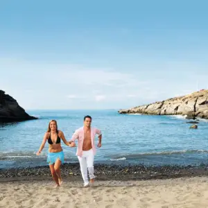 A couple running on the sand in Tenerife