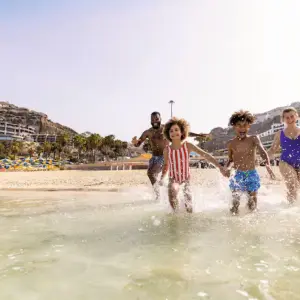 Family running into the sea in Gran Canaria