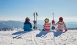 Heidi ski article main image showing three children in ski gear sitting on top of a mountain