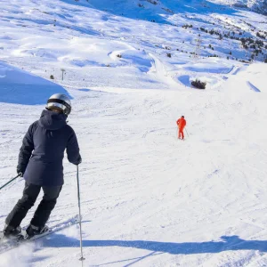 Flaine, France - shot from behind, a skier makes their way down the piste
