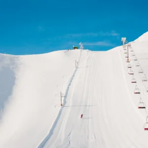 Arinsal, Andorra - wide shot of ski chair lifts going up a white, snowy mountain