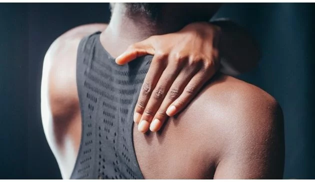 woman touching her upper back