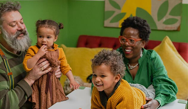 Family playing with grandchildren at home