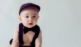 Baby wearing cap bow tie and braces