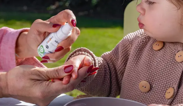 Adult using Vital Baby Hygiene Aquaint Cleansing Water on child