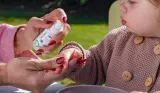 Adult using Vital Baby Hygiene Aquaint Cleansing Water on child