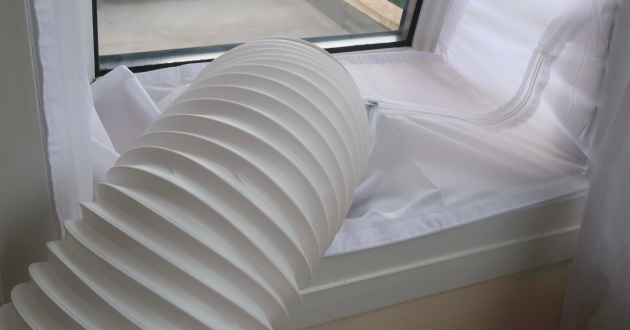 an air conditioner hose fitted to a hinged window