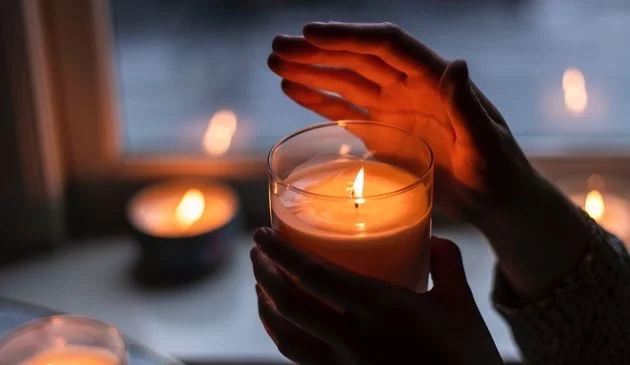 hands shielding candles