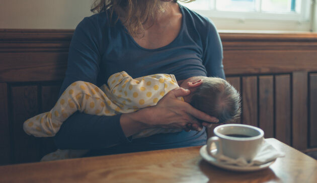 Woman breastfeeding in coffee shop