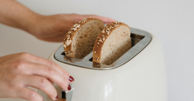 Woman making toast in a toaster