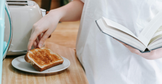 Woman grabbing slice of toast on the counter