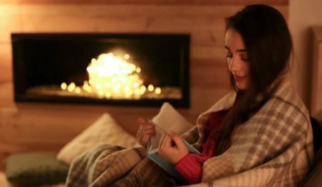 Woman reading in front of Fireplace