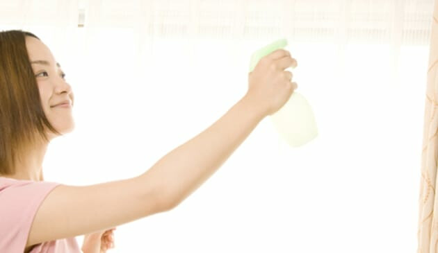 Woman spraying curtains