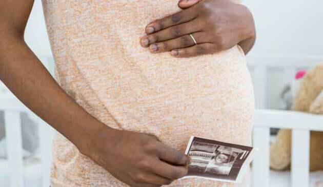 pregnant woman holding ultrasound scan picture