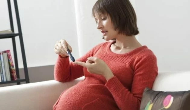 pregnant woman performing glucose test