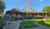 A man walks towards a Woodland Lodge at Alton Towers resort while pulling a suitcase