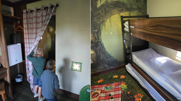 Two children peek behind a curtain to find their bunk bed