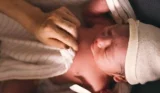 A newborn baby being wrapped in a cloth