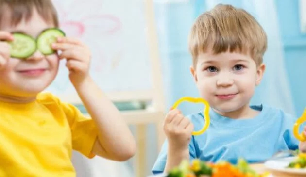 Toddler holding pepper slice