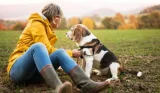 Woman wearing wellies sat next to a dog