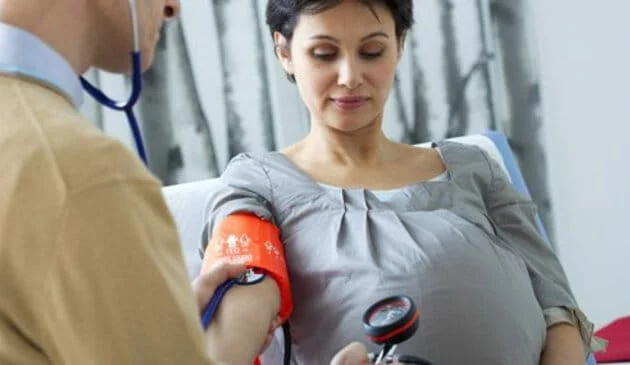 pregnant woman having blood pressure checked