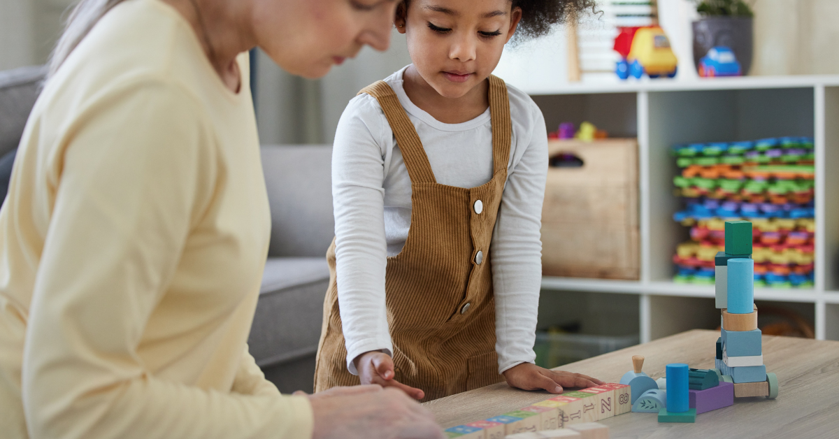 Child and adult playing with wooden blocks