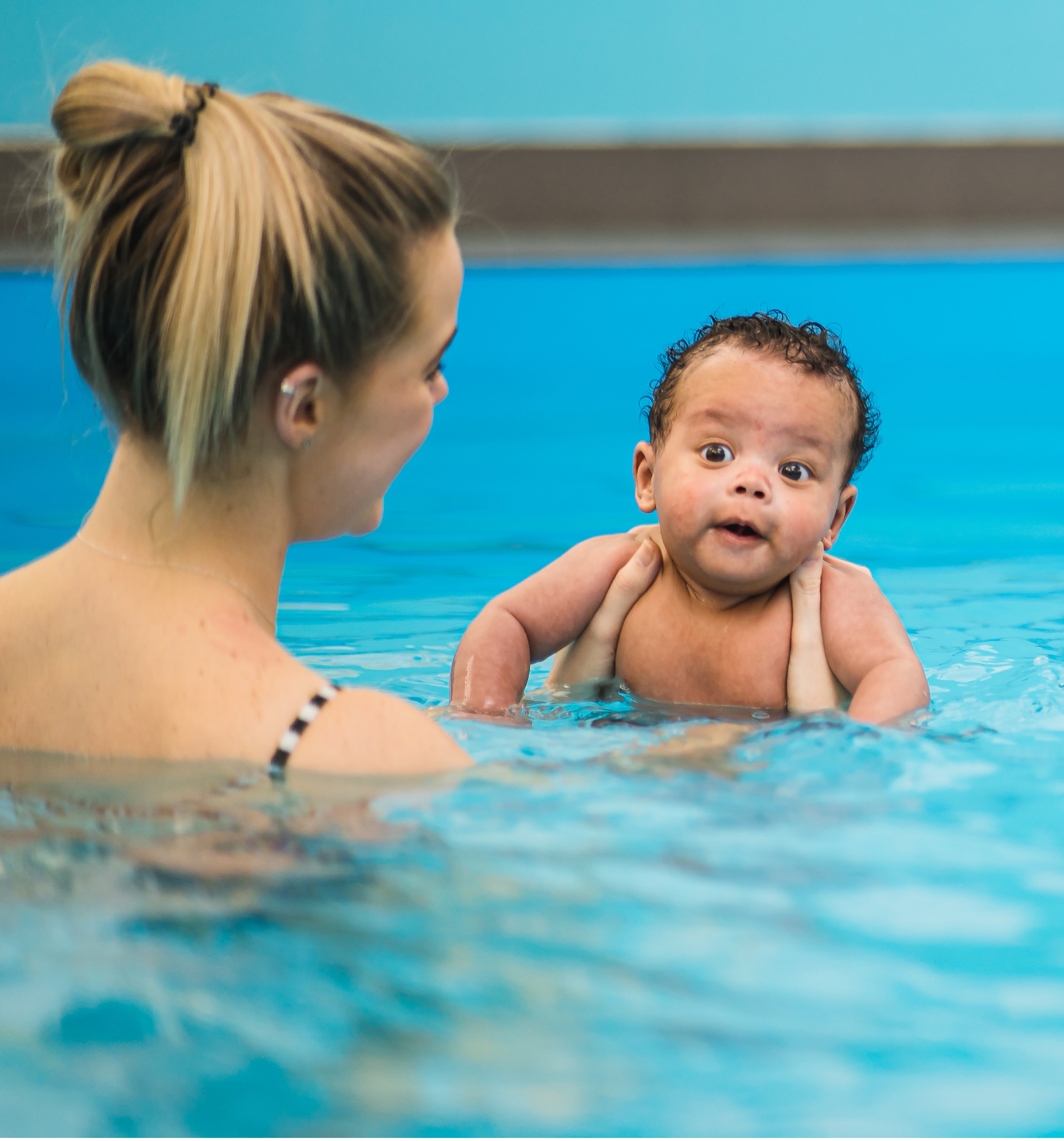 A mother and baby taking part in a Puddle Ducks swimming lesson